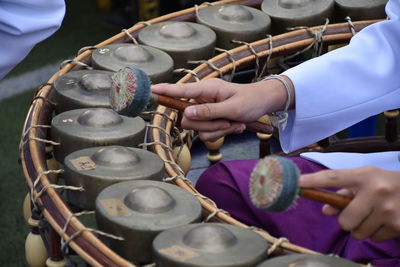 Cropped hands of woman playing cymbal during event