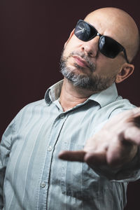 Young man wearing sunglasses against black background