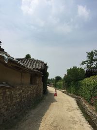 Footpath by building against sky