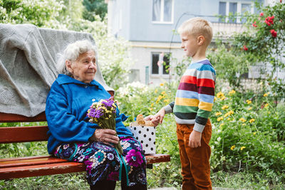 90 year old great-grandmother, grandmother with grandson together. grandson hugs his 