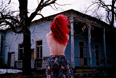 Rear view of shirtless woman standing outdoors