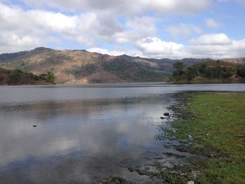 Scenic view of lake against cloudy sky