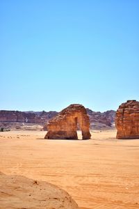 Rock formations in desert against clear blue sky