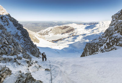 High angle view of man climbing on snowcapped mountains