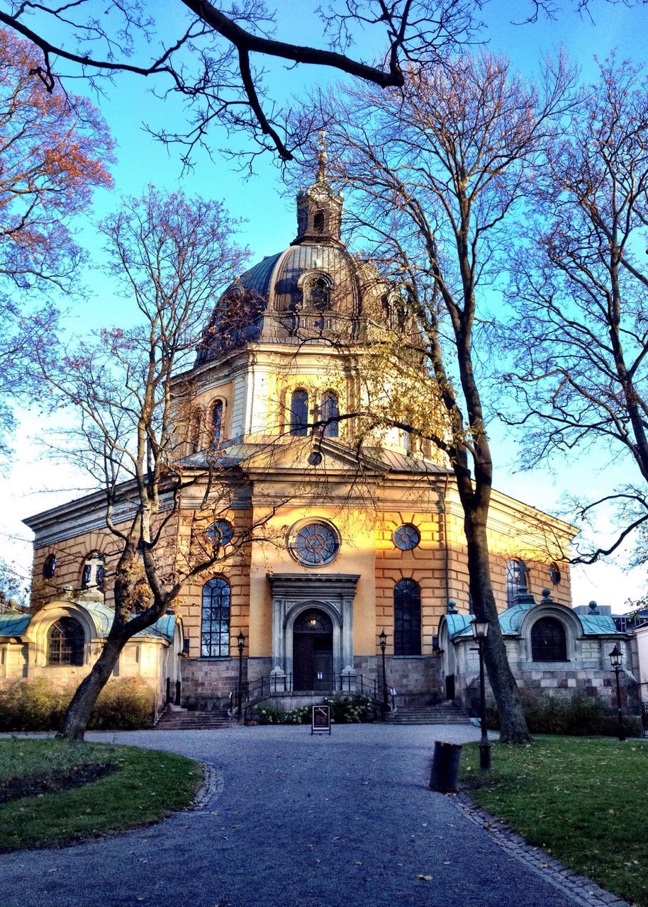 architecture, building exterior, place of worship, built structure, religion, church, spirituality, tree, cathedral, dome, facade, sky, famous place, travel destinations, bare tree, clear sky, low angle view, branch