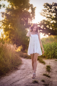 Young beautiful woman in white dress in corn field.