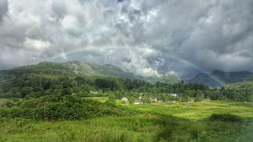 Scenic view of field against storm clouds