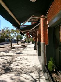 Empty footpath amidst buildings in city