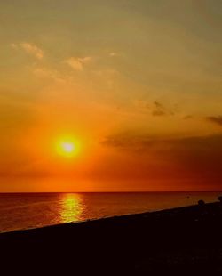 Scenic view of sea against orange sky