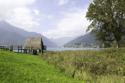 Built structure on field by mountains against sky