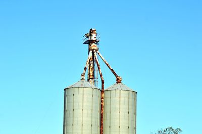 Low angle view of crane against clear blue sky