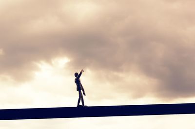 Low angle view of silhouette man standing against sky