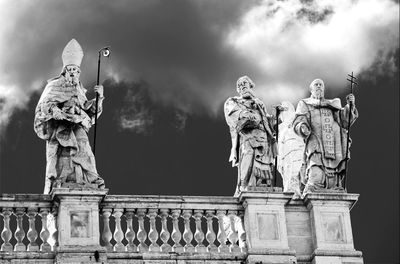 Low angle view of statues against sky