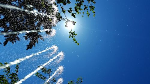 Low angle view of fountain against clear blue sky