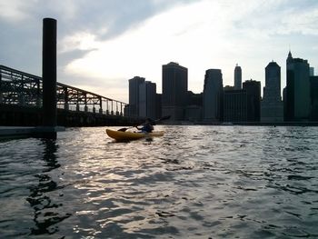 Boats in river with buildings in background