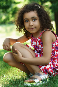 Portrait of young woman sitting on field