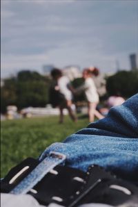 People on grass against sky