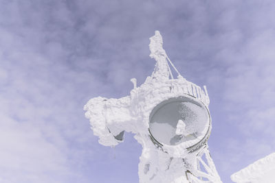 Low angle view of cross sculpture against sky