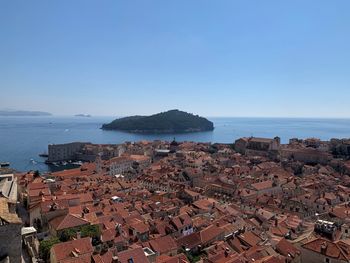 High angle view of townscape by sea against clear sky