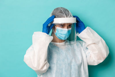 Portrait of girl standing against blue background