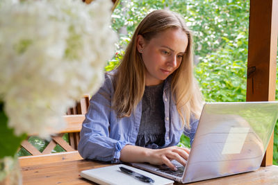 Young woman using laptop at table