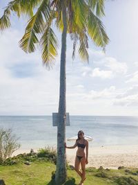 Young woman wearing bikini standing at beach