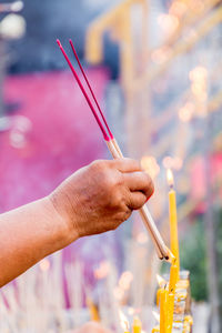 Close-up of hand lighting incenses