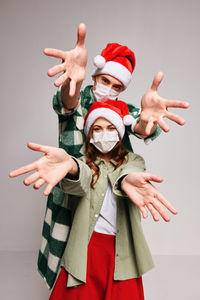 Portrait of couple gesturing against gray background