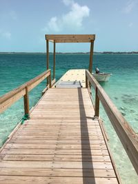 Wooden pier on sea against sky