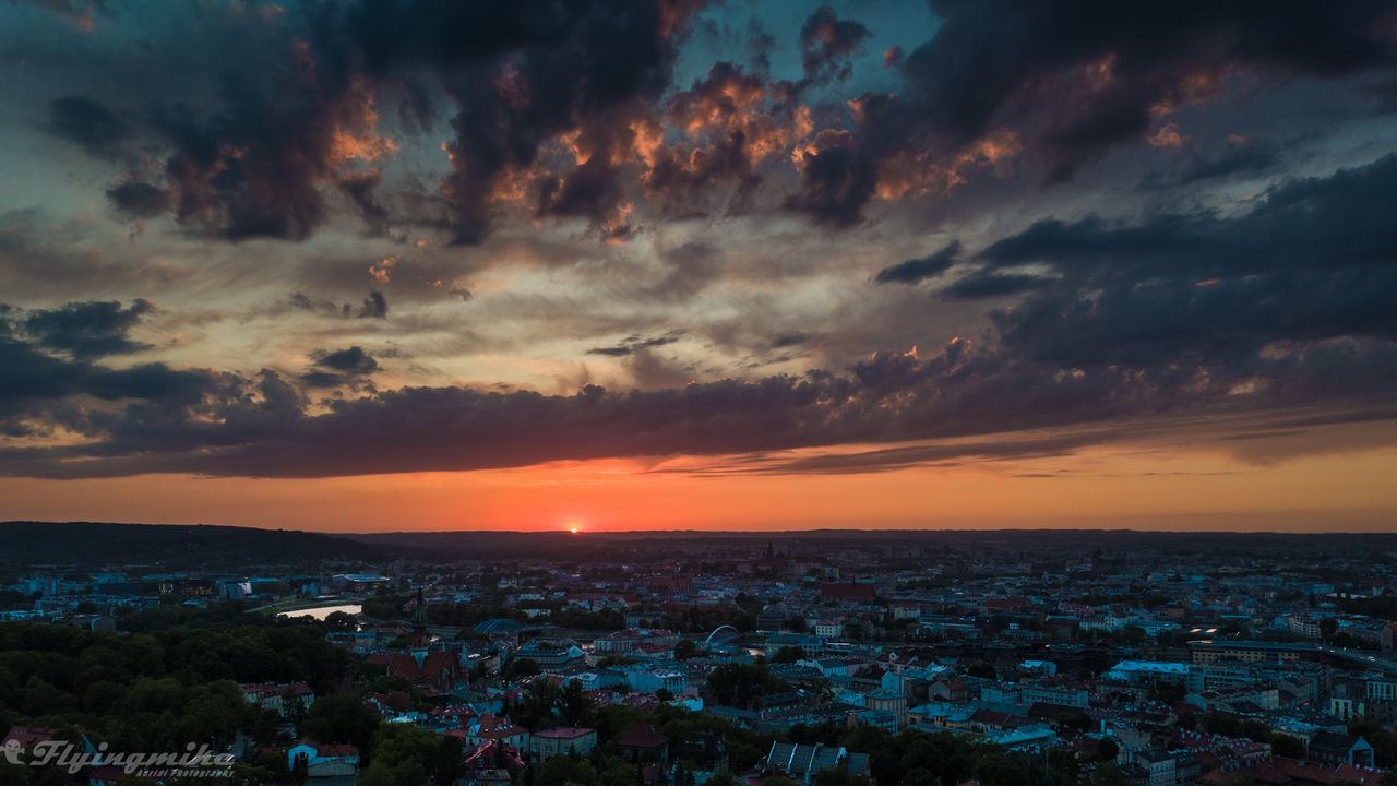 HIGH ANGLE VIEW OF TOWNSCAPE AGAINST SKY AT SUNSET