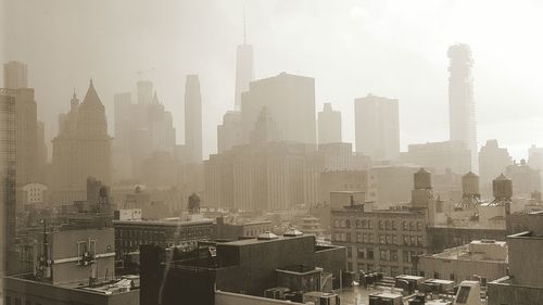 View of cityscape against foggy weather