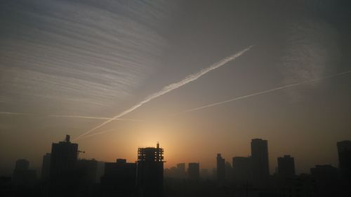 Vapor trails in sky at sunset