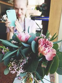 Low angle view of woman holding pink flower