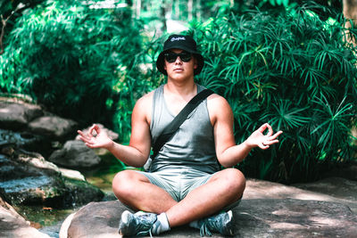 Young man sitting on rock