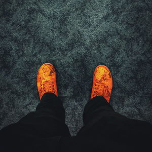 Low section of person standing on orange floor