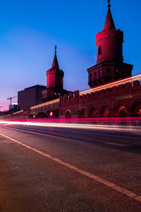 Light trails on road against buildings at night