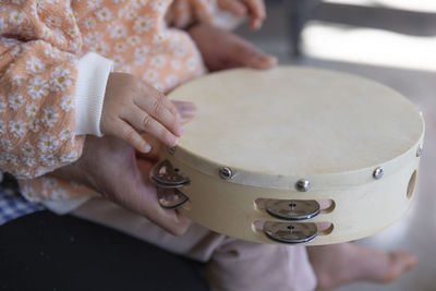 Midsection of woman playing guitar