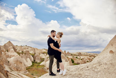 Full length of couple standing against sky