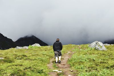 Rear view of woman on mountains against sky