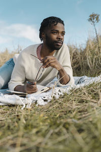 Full length of young man sitting on field