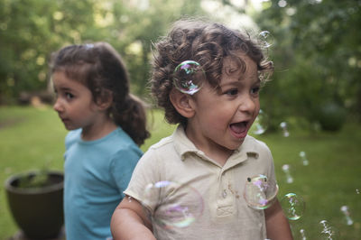 Boy playing with bubbles at park