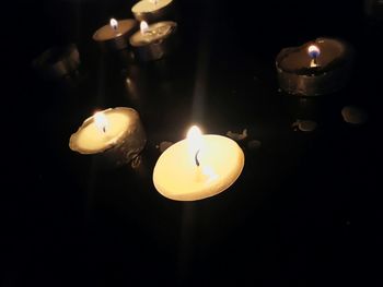 Close-up of lit candle in darkroom