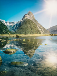 Scenic view of lake and mountains against blue sky