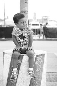 Full length of cute boy sitting outdoors