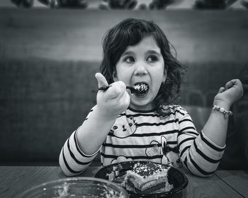 Portrait of young girl eating cake