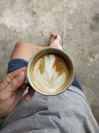 Midsection of man holding coffee cup