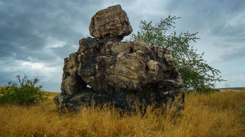 Rock formation on field against sky