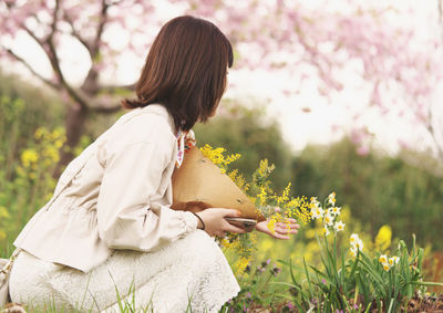 Woman and flowers rejoice in spring.