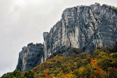 Rock for climbing against a autumn foliage forest, pietra di bismantova, reggio emila, italy