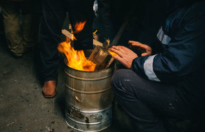 High angle view of man warming hands over bonfire